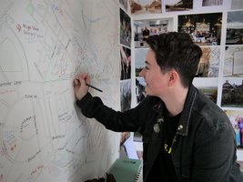 Person drawing onto a wall with a map of Barnsley on it