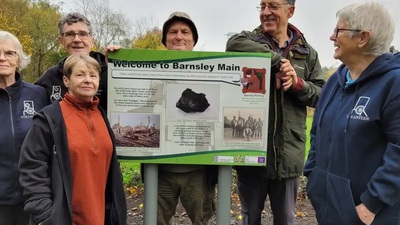 The group of volunteers stood around one of the interpretation panels at Barnsley Main