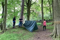 Three people pitching a tent