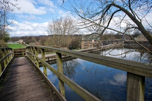 Reserviour at Worsbrough Mill with a bridge over it and blue skies