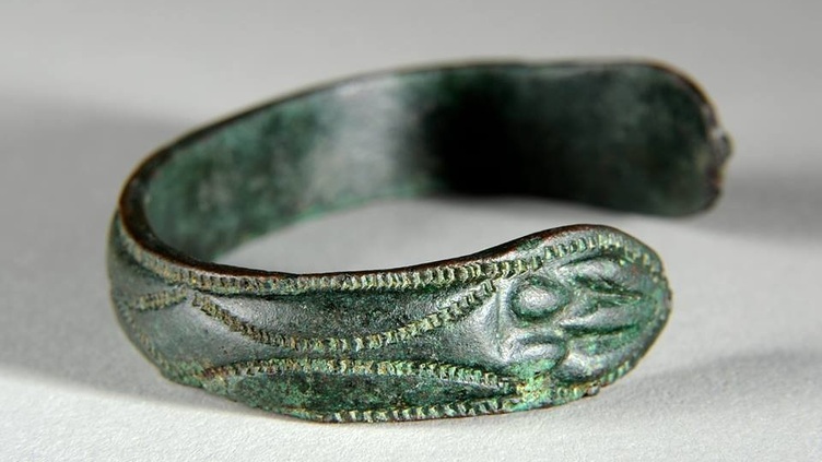 A metal bracelet with decorations carved into it