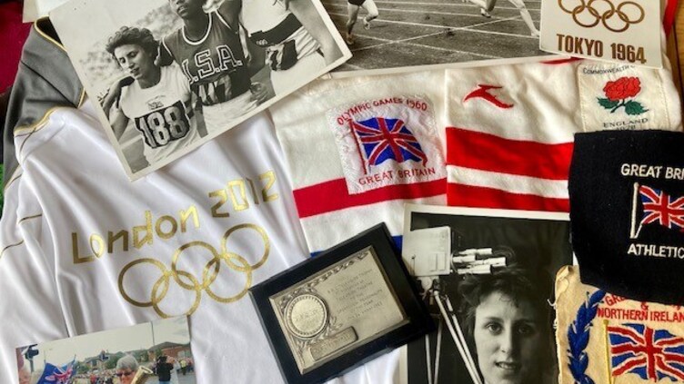 A collection of Olympic memorabilia, including black-and-white sports photos, London 2012 shirt, Tokyo 1964 poster, badges, an engraved plaque, and embroidered patches from Great Britain and Northern Ireland athletics.