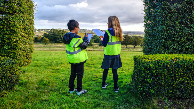 Two children drawing the landscape outdoors 
