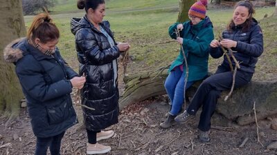 Group of people lashing sticks togteher