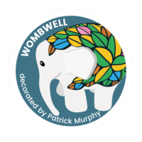 Wombwell Elephant by Patrick Murphy – an elephant with a white face and legs and leaves of green, yellow, blue and pink on the body