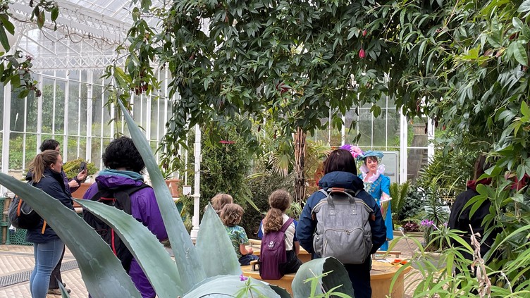 Woman dressed as Lady Wortley speaking to an audience in the greenhouse