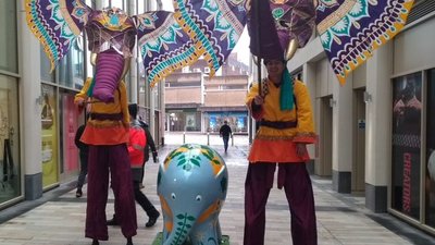 Performers on stilts wearing elephant masks