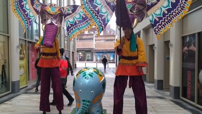 Performers on stilts wearing elephant masks