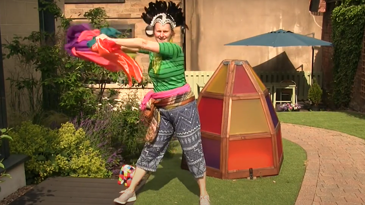 Woman dancing outide in the Cooper Garden with coloured ribbon