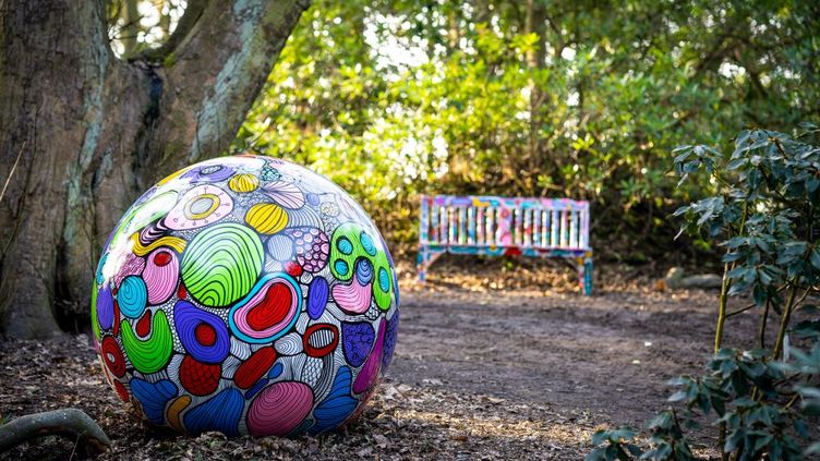 Colourful spherical sculpture in the woods