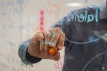 Person wrtiting on a translucent board.