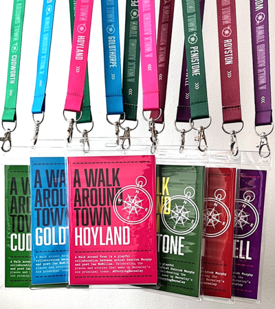 Colorful lanyards with cards labeled 'A Walk Around Town' for various Barnsley towns, featuring compass graphics