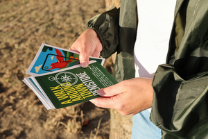 Person holding 'A Walk Around Town' Penistone card pack, standing outdoors