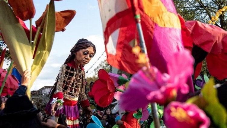 Another photo of the Amal puppet surrounded by large colourful paper flower creations