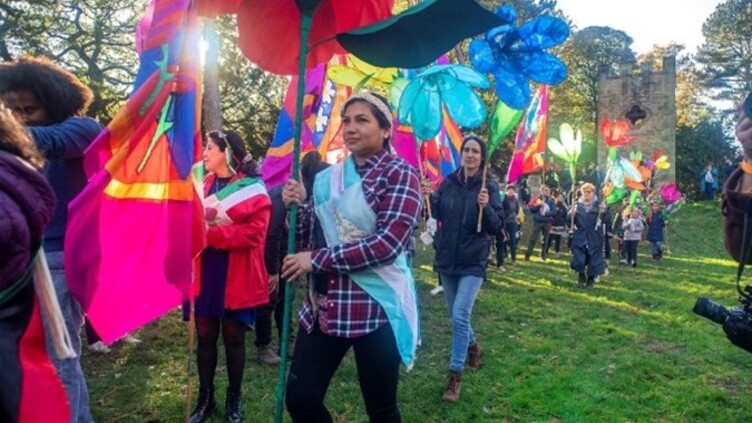 Crowd of people holding giant flowers