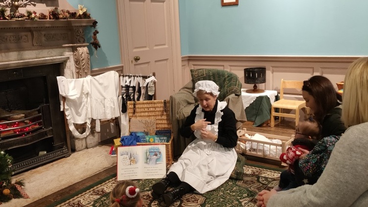 People sat on the floor in a room in Cannon Hall during a storytelling session