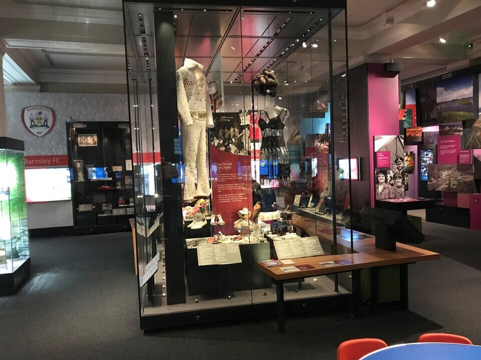 Exhibition display with an assortment of various clothing and household items.