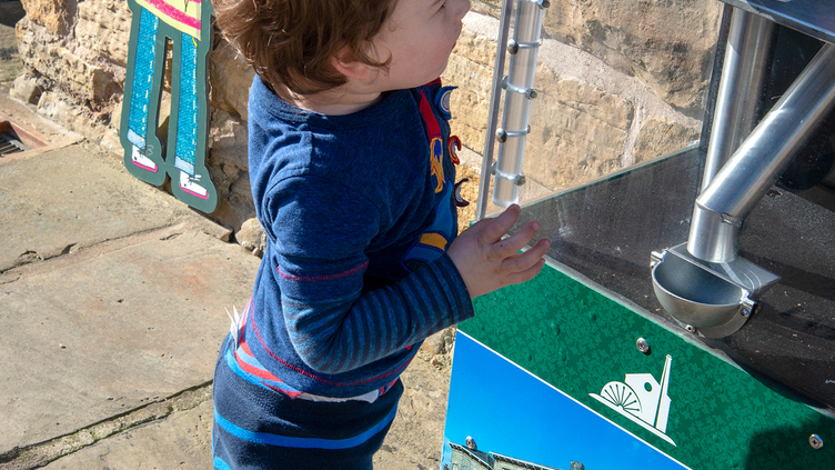 A boy using the make your own penny machine at Elsecar Heritage Centre