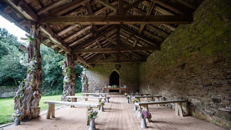 Historic deer shelter benches arranged for a wedding decorated with flowers